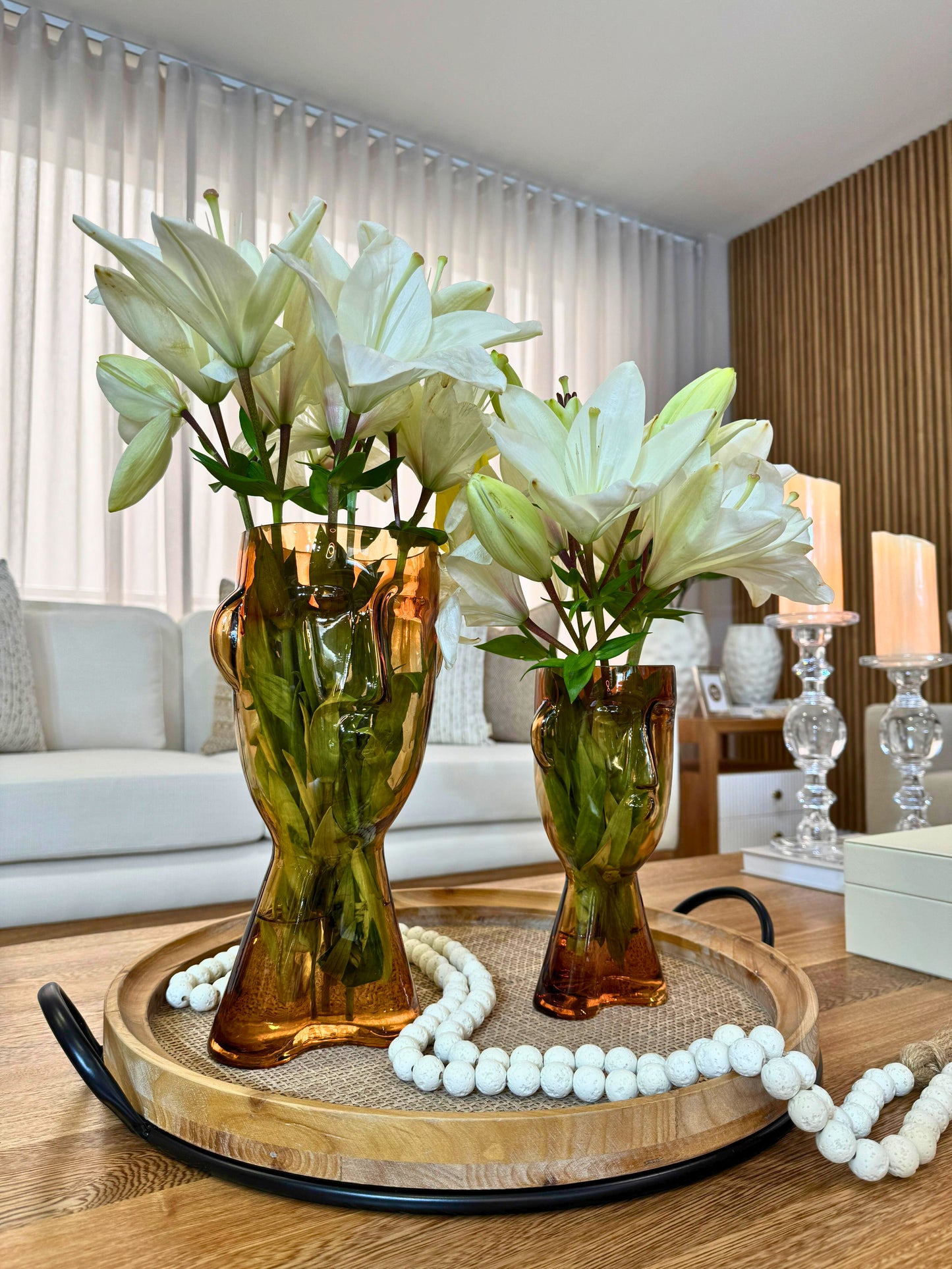 Detalle de jarrones en cristal color ámbar con diseño de caras, floreros artísticos para decoración