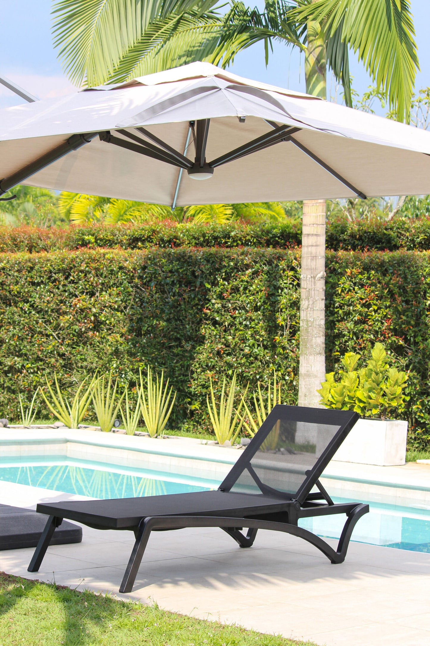 Detalle de asoleadora MARE, camastro de resina con malla Serge Ferrari sumergible en agua
