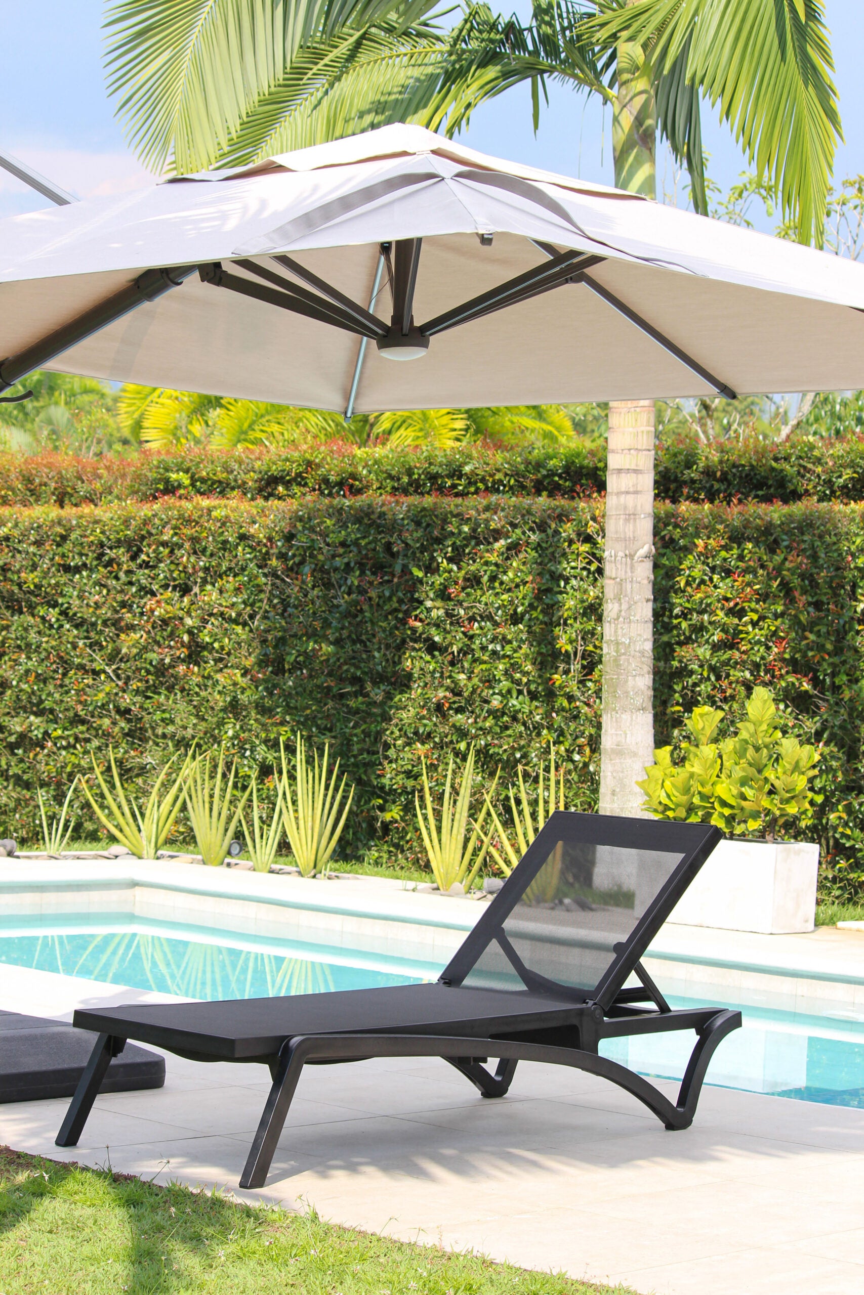 Detalle de asoleadora MARE, camastro de resina con malla Serge Ferrari sumergible en agua
