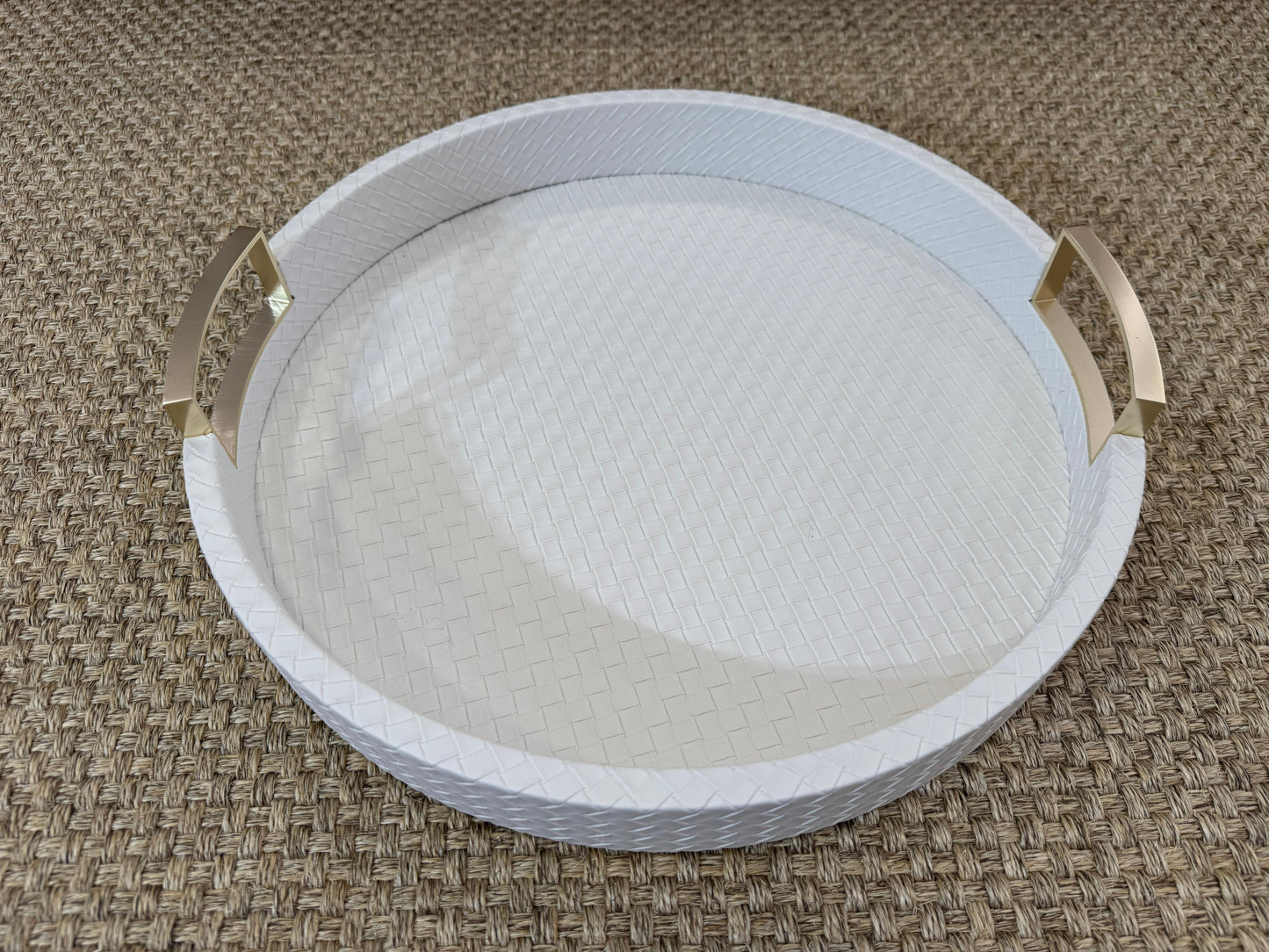 Bandeja decorativa redonda en polipiel blanca con asas metálicas doradas, estilo moderno y sofisticado