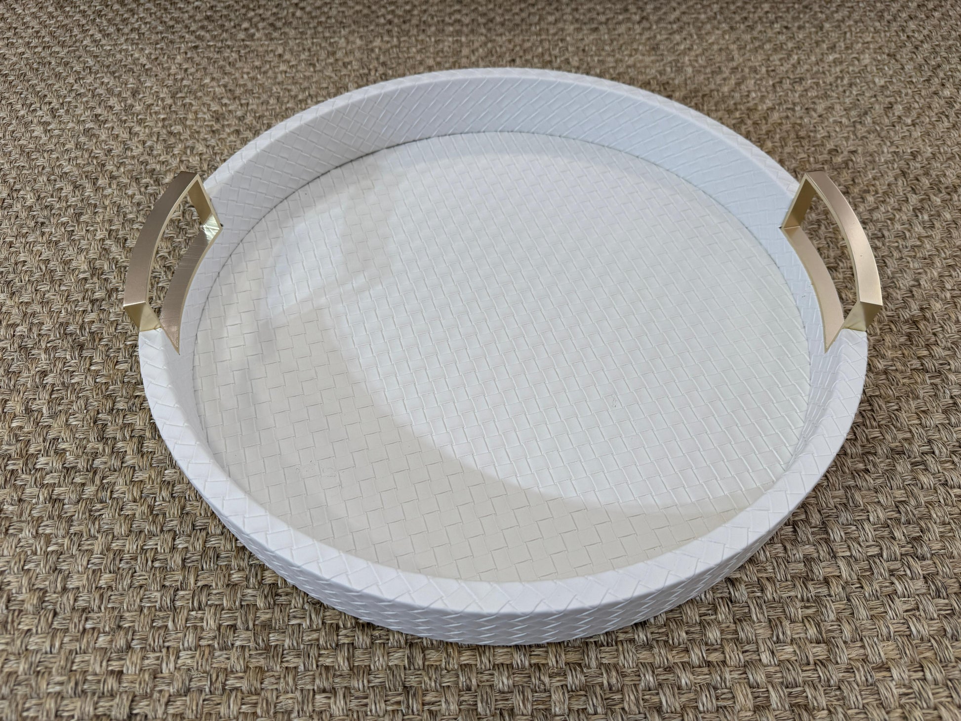 Bandeja decorativa redonda en polipiel blanca con asas metálicas doradas, estilo moderno y sofisticado