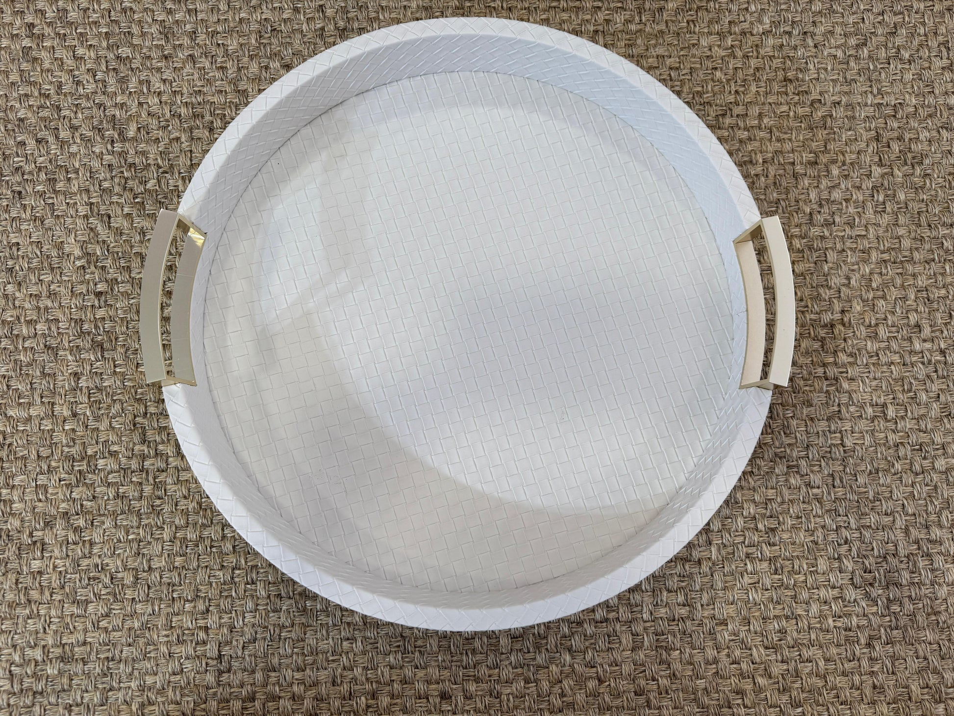 Bandeja redonda de madera con polipiel blanca y asas doradas, ideal para servir y decorar espacios elegantes