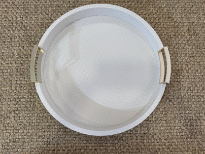 Bandeja redonda de madera con polipiel blanca y asas doradas, ideal para servir y decorar espacios elegantes
