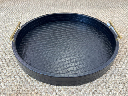 Bandeja decorativa redonda en polipiel negra con asas metálicas doradas, estilo moderno y sofisticado