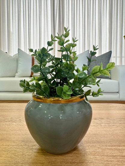 Detalle de jarrón decorativo en cerámica gris y dorado, florero elegante con acabado brillante