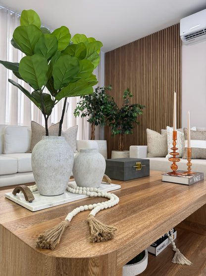 Vista de jarrones en resina blanco grisáceo, floreros decorativos para mesa de centro.

Detalle de candelabros de cristal ámbar, set de portavelas decorativos para sala.