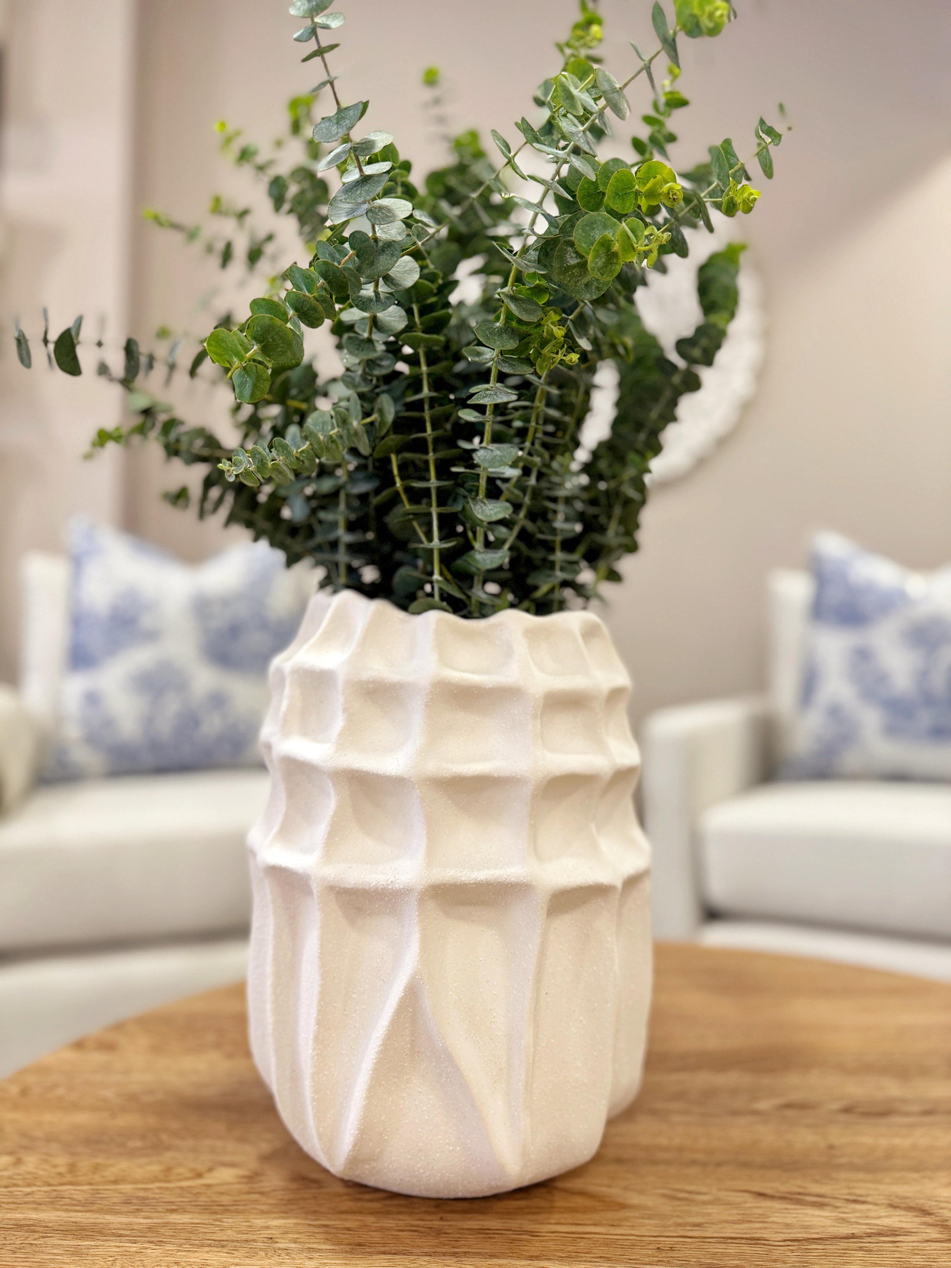 Detalle de jarrones blancos con textura en resina, floreros decorativos modernos para sala