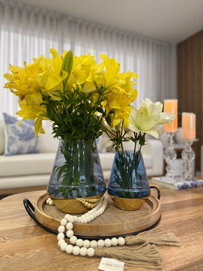 Detalle de jarrones de cristal azul con base cromada dorada, floreros decorativos elegantes para sala