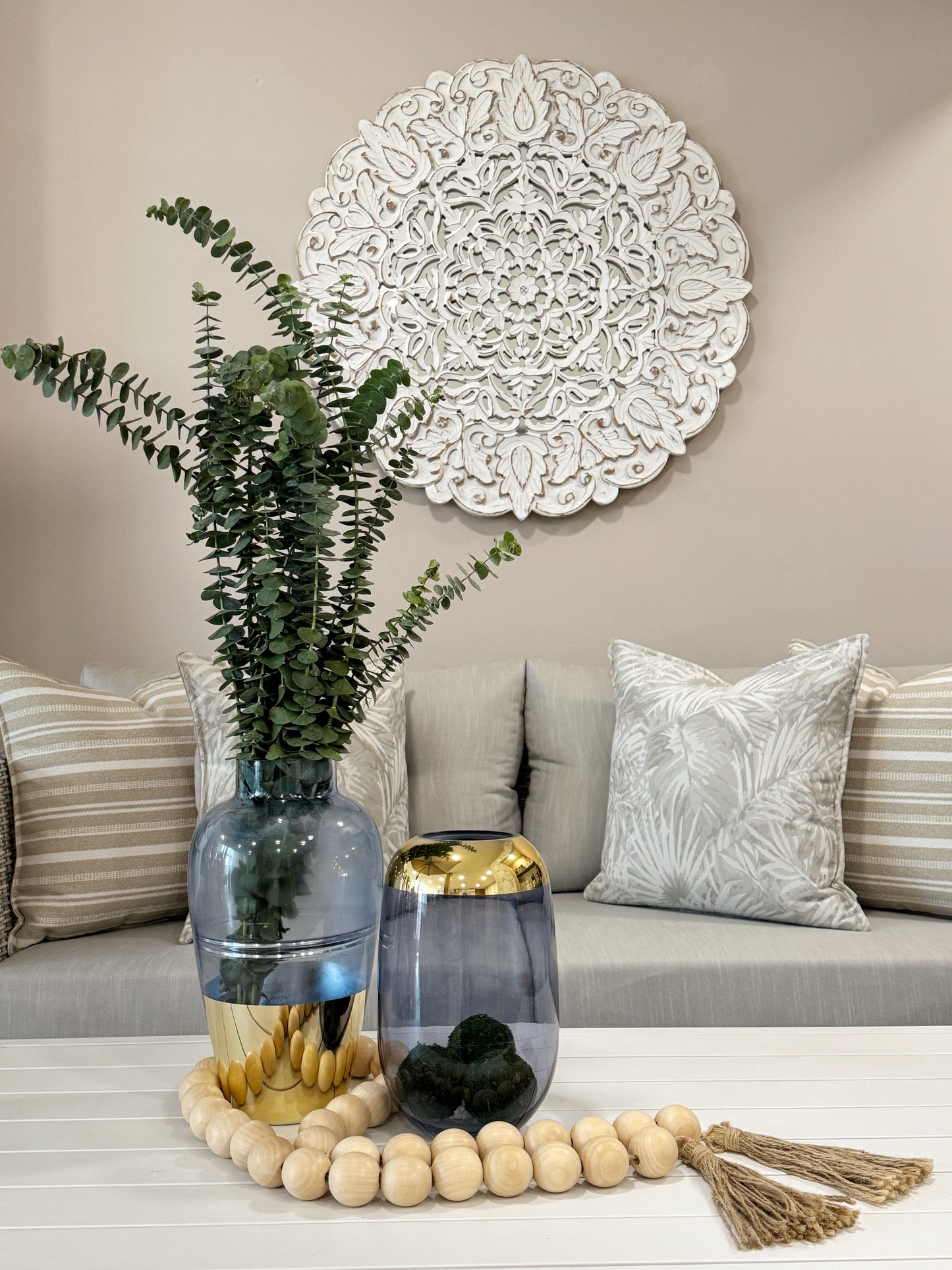 Detalle de jarrones de cristal azul con cromado dorado, floreros decorativos elegantes para sala.

Mandala redonda de madera tallada a mano con espejo Ø 90cm, arte decorativo de pared importado de India.