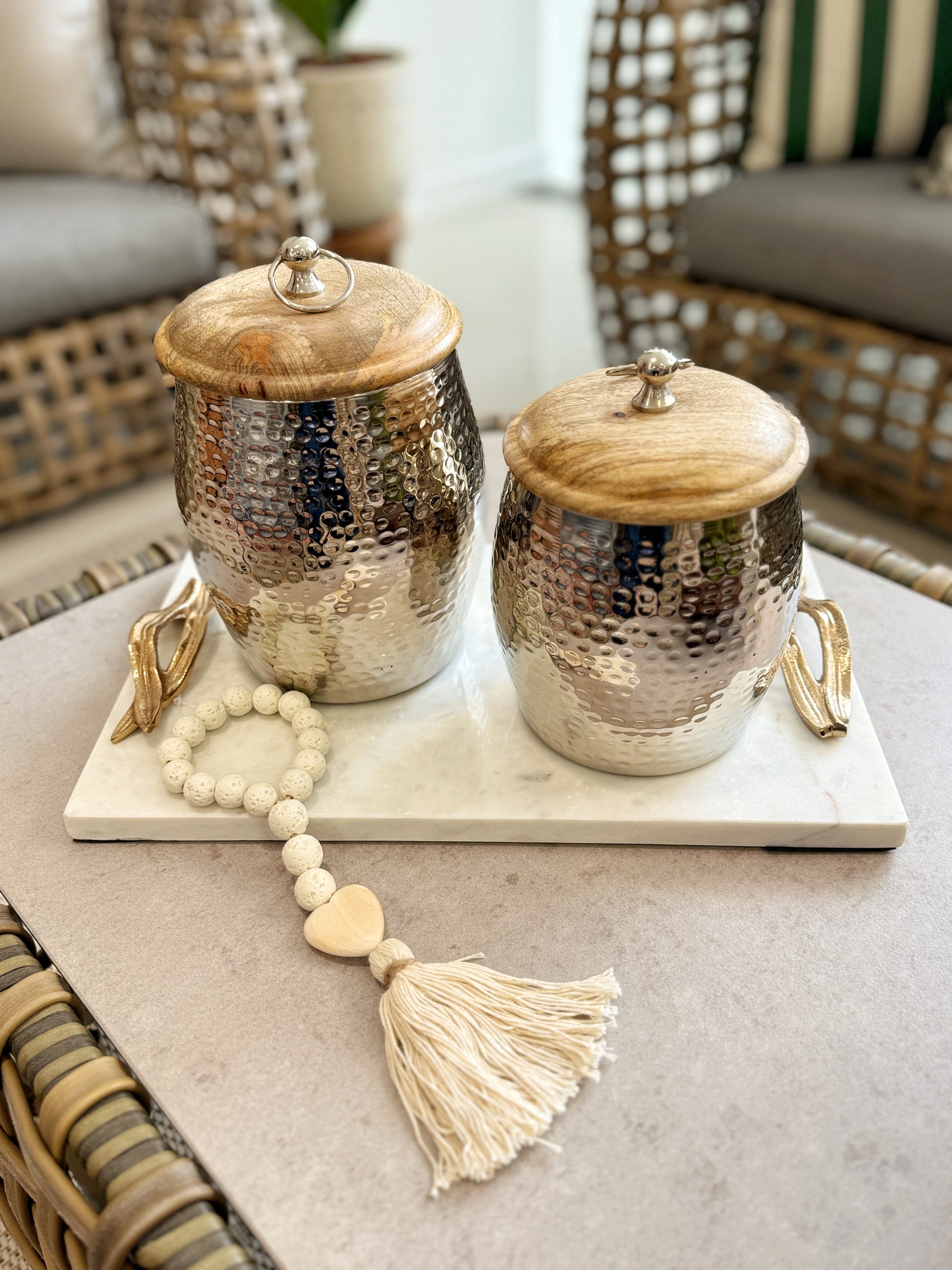 Detalle de borlas decorativas blancas con corazón de madera natural
Detalle de ánforas decorativas en aluminio con tapa de madera, jarrones modernos para decoración