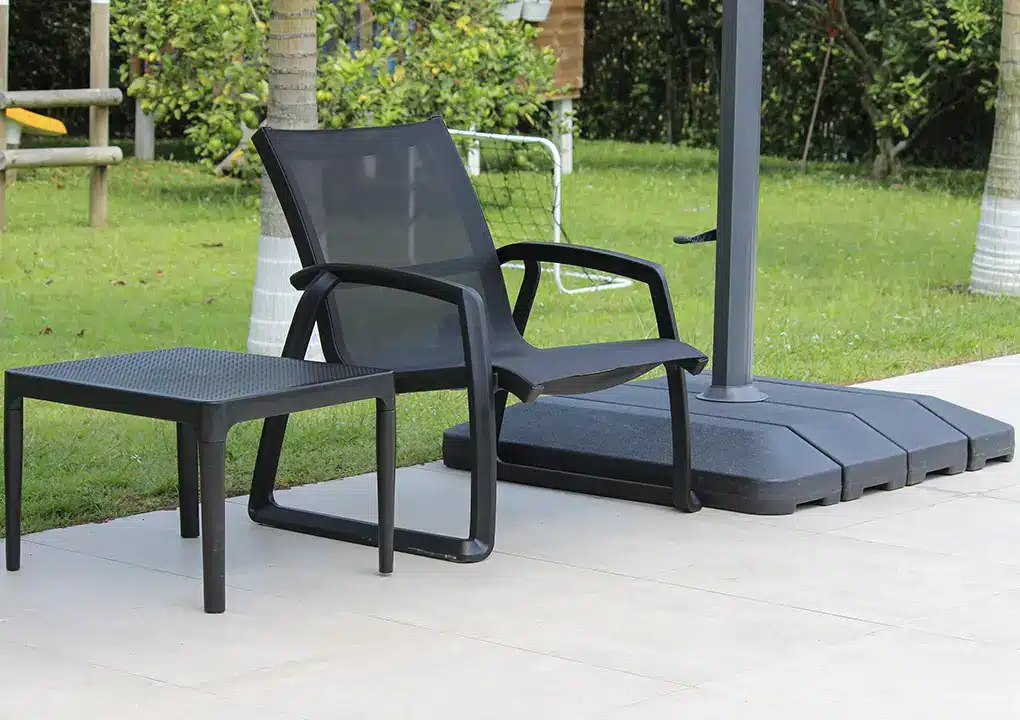 Sofá sencillo MARE negro con mesa TERRA, sofá de resina con malla Serge Ferrari apilable para piscina
