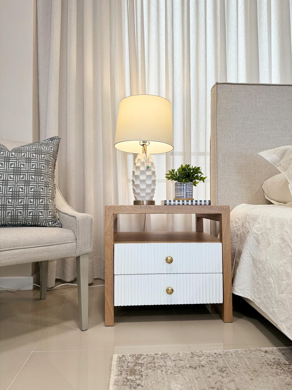 Detalle de mesa de noche en madera flor morado con pomos dorados cromados, mobiliario interior de calidad