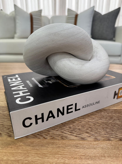 Detalle de nudo decorativo en madera blanca mate, escultura moderna para decoración de sala