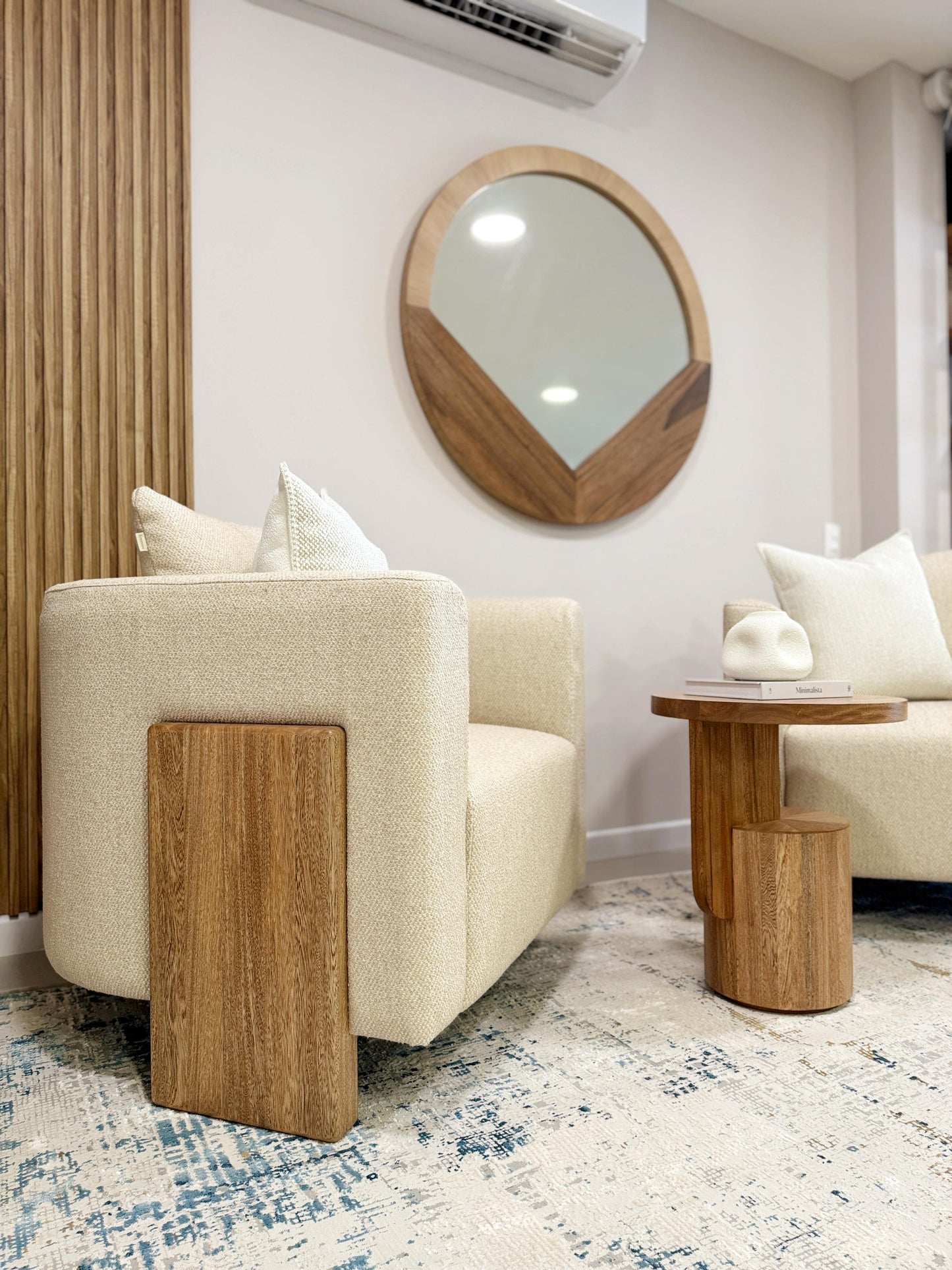 Vista de poltrona tapizada en chenille con protección anti fluidos, base de madera maciza natural