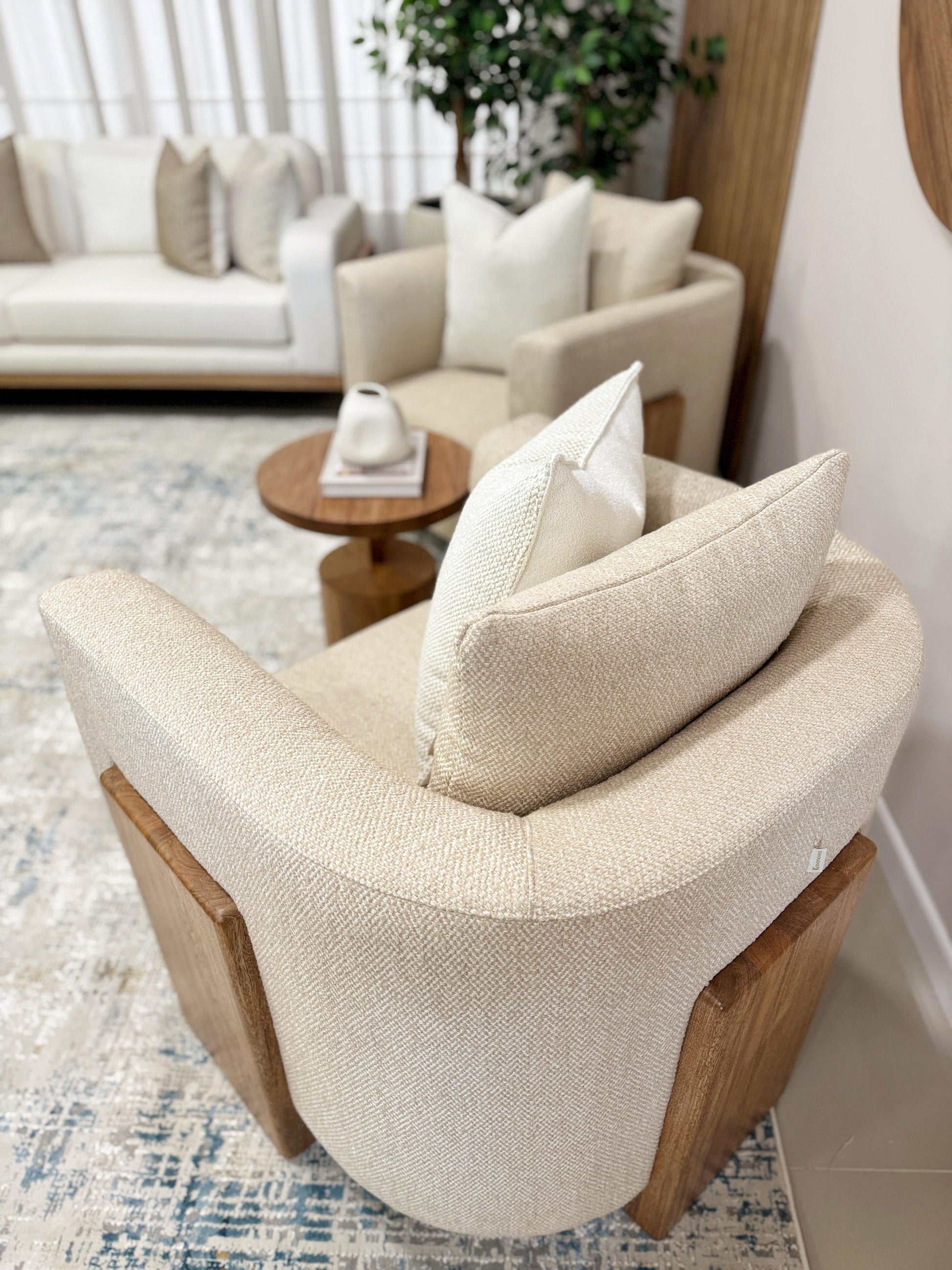 Detalle de poltrona en chenille con protección anti fluidos, base de madera flor morado poro abierto