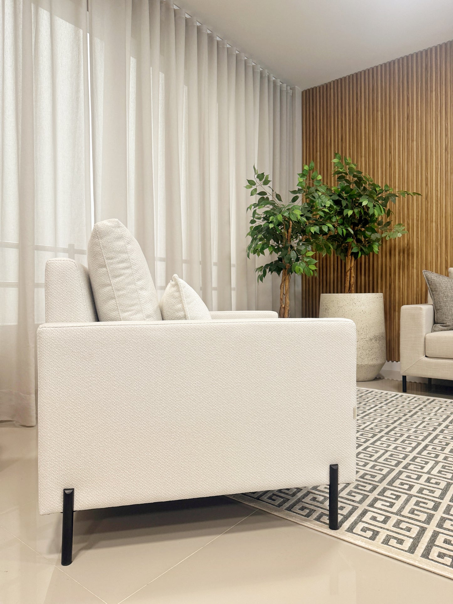 Detalle de poltrona TOKIO tapizada en tela aquaclean, patas metálicas negras con diseño contemporáneo