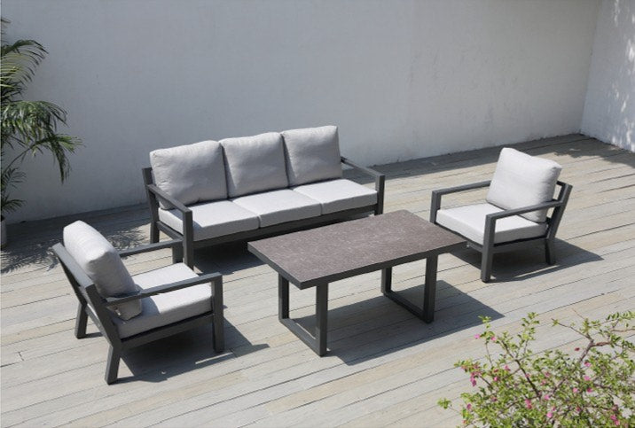 Detalle de sala SALINE negra, sofás de aluminio con cojines gris oscuro y mesa altura comedor
