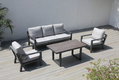 Detalle de sala SALINE negra, sofás de aluminio con cojines gris oscuro y mesa altura comedor
