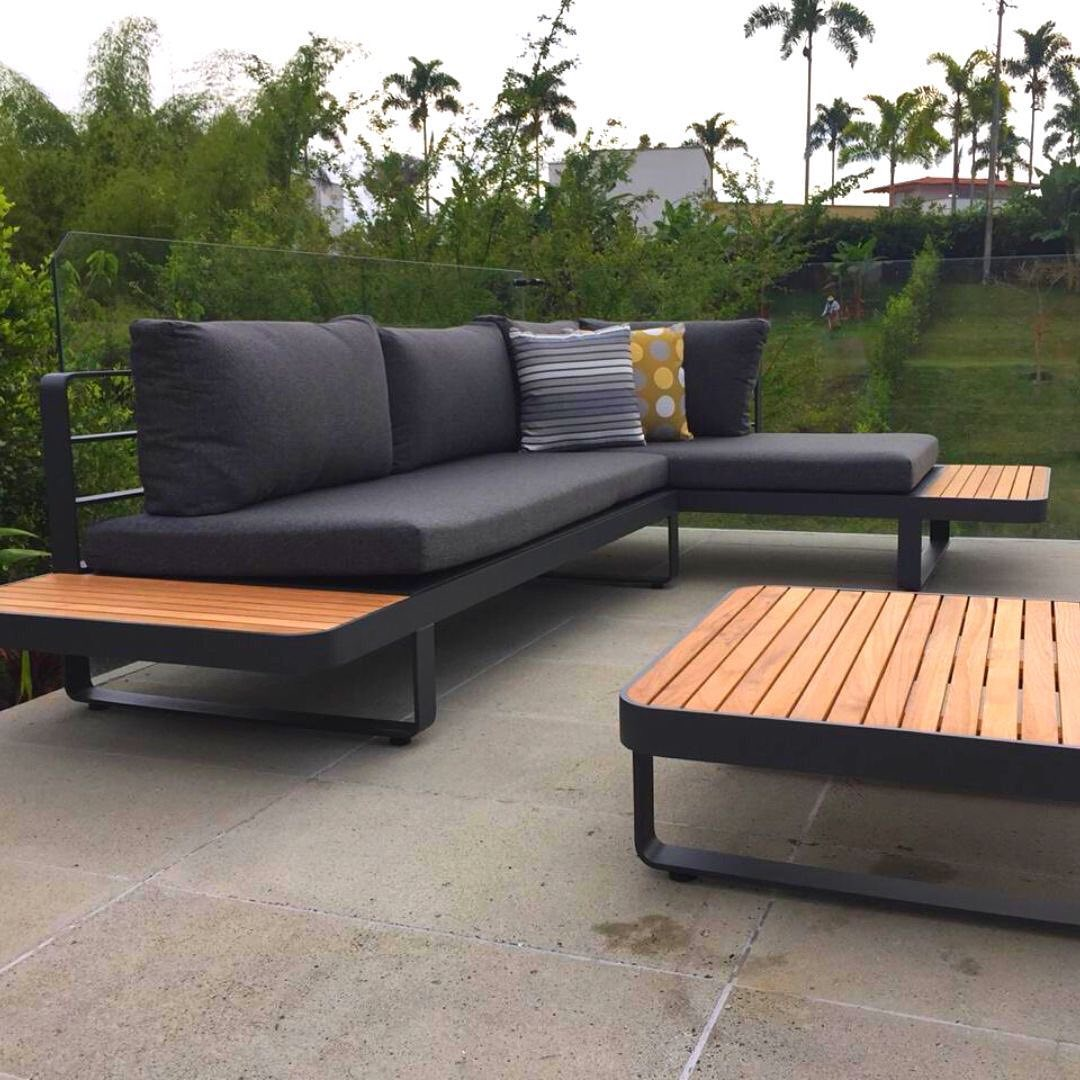 Vista de sala CARTAGENA, conjunto de sofás de aluminio con bandejas de teca y cojines decorativos
