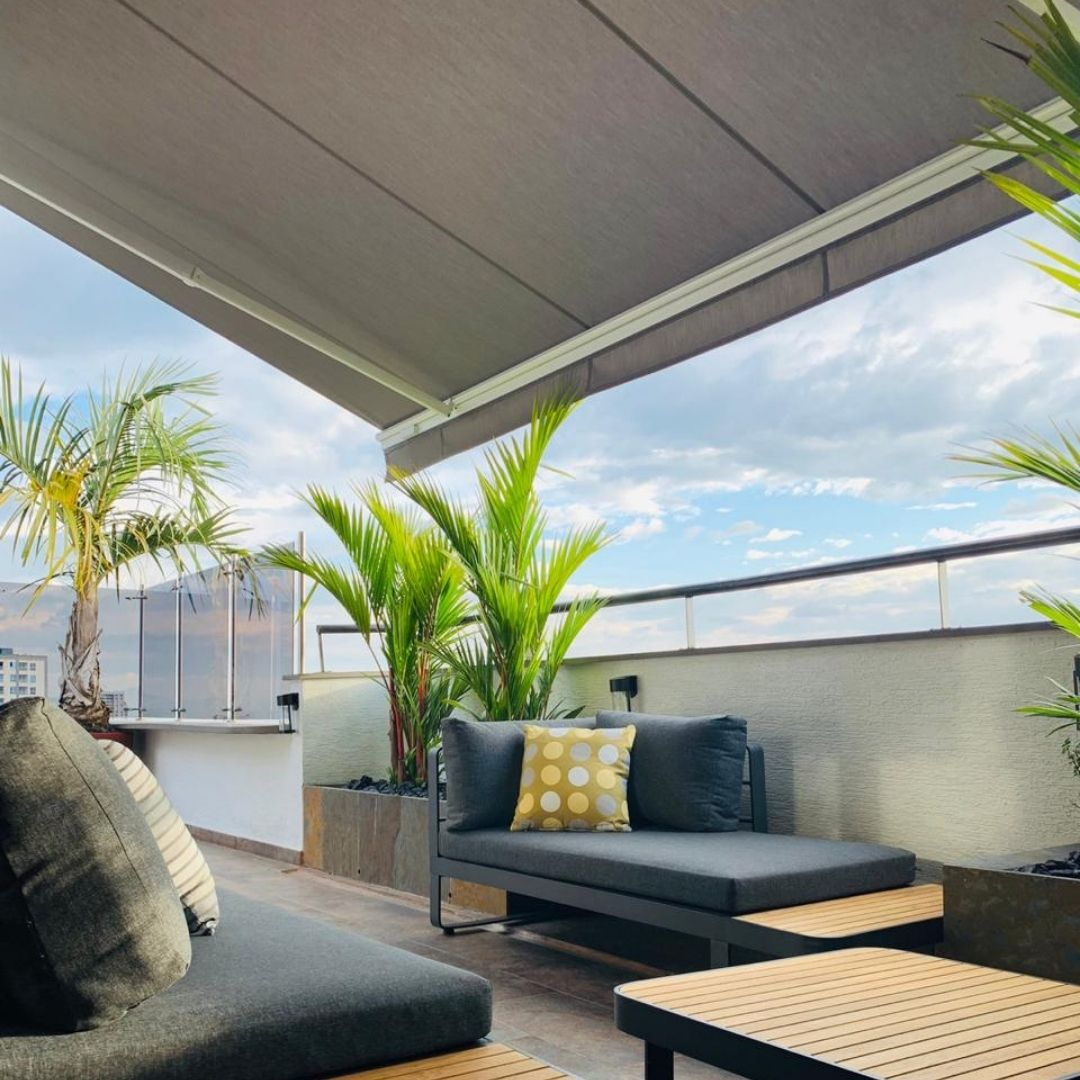 Detalle de sala CARTAGENA gris oscuro, sofás de aluminio con bandejas de madera teca y cojines
