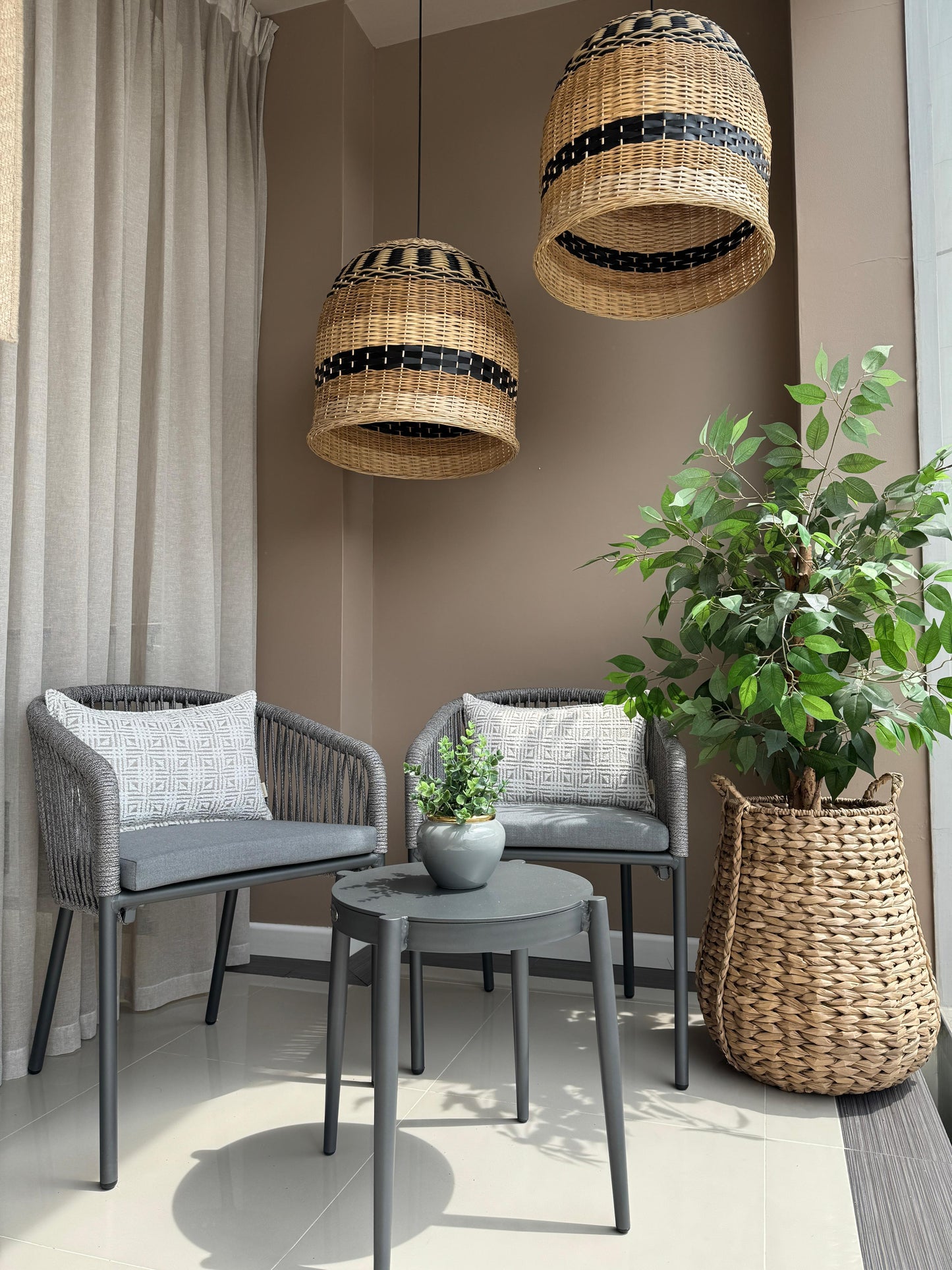 Silla BOWDON en uso, silla de aluminio negro con cuerdas de poliéster para terraza cubierta.

Detalle de mesa auxiliar GENOVA, mesa redonda de aluminio negro para exterior bajo techo.