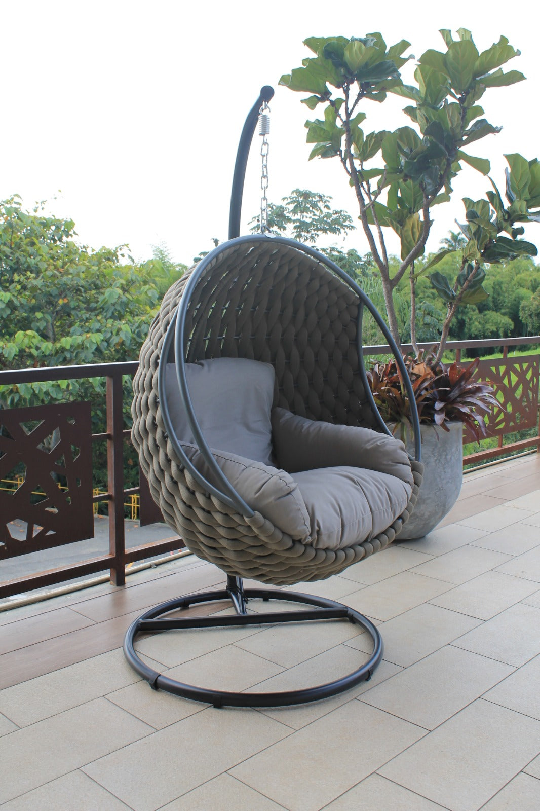 Vista de silla colgante ROPE, silla de aluminio con fibra termoplástica y cojines café para balcón
