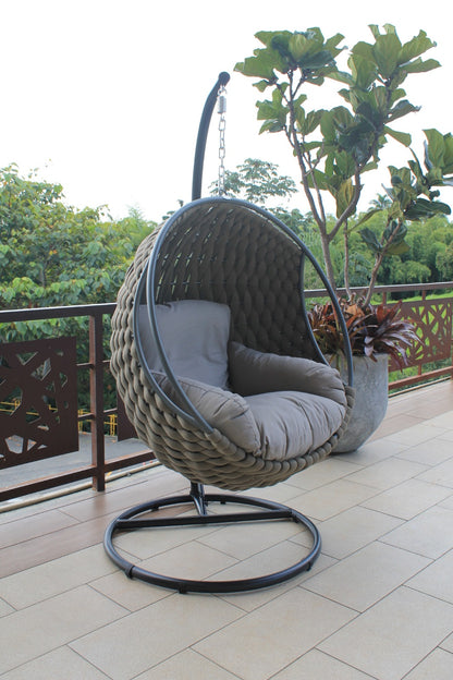Vista de silla colgante ROPE, silla de aluminio con fibra termoplástica y cojines café para balcón
