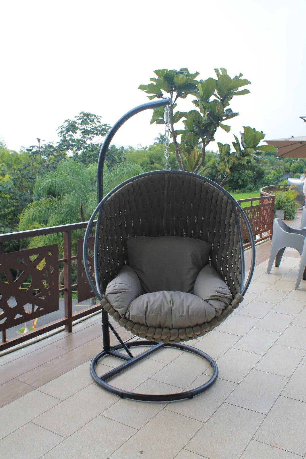 Detalle de silla colgante ROPE, silla de aluminio con fibra termoplástica y cojines café
