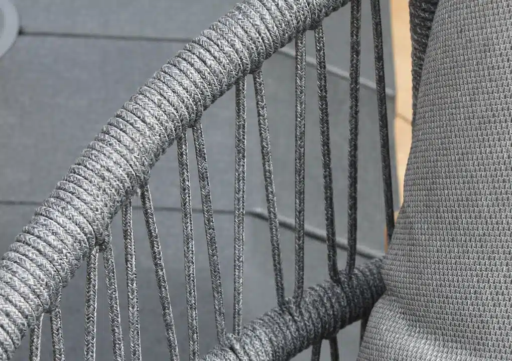 Detalle de silla mecedora BARICHARA, mecedora de aluminio con cuerdas grises y patas de teca
